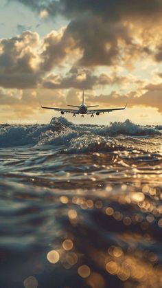 an airplane is flying over the ocean at sunset or sunrise with waves in foreground