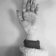 black and white photograph of a person's hand with two rings on their fingers