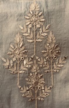 an embroidered piece of cloth with flowers and leaves