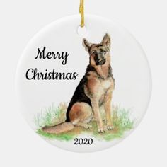 a christmas ornament with a german shepherd dog sitting on the grass in front of it