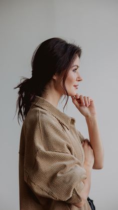 a woman standing with her hands on her chin