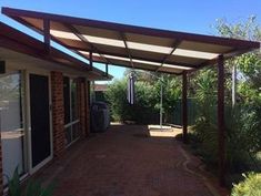 an outdoor covered patio area with brick walkway