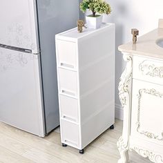 a white refrigerator freezer sitting next to a sink in a kitchen on top of a hard wood floor