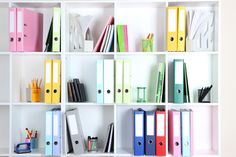 a book shelf filled with lots of books and binders on top of each other