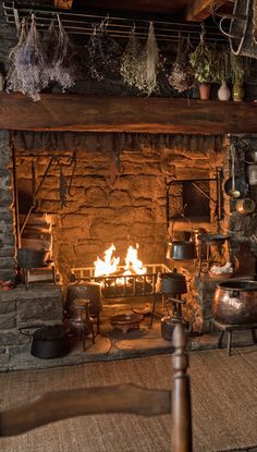 an old fashioned fireplace with pots and pans on it