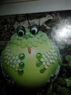 an apple decorated like a frog with eyes