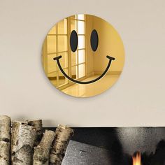 a mirror with a smiley face on the wall next to fire place and tree trunks