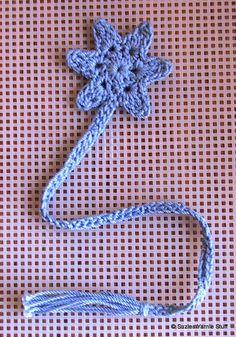 a crocheted flower on a blue string