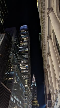 looking up at the top of two skyscrapers in new york city, ny by night