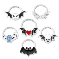 six pairs of halloween hoop earrings with bats and skulls on the front, one has a red heart in the middle