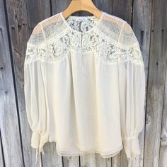 Rebecca Taylor Silk Chiffon Lace Blouse Cream 8 Super Cute Ultra Chic Romantic Feminine Flowy Silk Chiffon Blouse With Lace Detail Long Sleeve Tie Cuffs Round Neck Front Button Keyhole Lace Detail At Yokes And Shoulders Round Hem Lined 100% Silk Minimalist Minimalism Capsule Romantic Feminine Flowy Lightweight Boho Bohemian Approx Length 25” Pit To Pit 21” Great Condition Faint Stain On Tie Wear Once And Clean Smoke And Pet Free Home Long Sleeve Chiffon Blouse For Daywear, Feminine Chiffon Blouse For Brunch, Elegant Tops With Sheer Sleeves For Brunch, Spring Daywear Blouse With Sheer Sleeves, Long Sleeve Blouse With Lace Patchwork For Brunch, Chiffon Blouse With Blouson Sleeves, Feminine Fall Blouse With Lace Patchwork, Feminine Lace Patchwork Blouse For Fall, Feminine Blouse With Lace Collar For Brunch