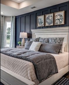 a bedroom with blue walls and white bedding