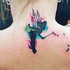 the back of a woman's neck with a colorful tattoo design on her left shoulder