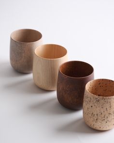 five wooden bowls lined up on a white surface