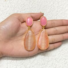 Pink Quartz and orange gemstone hanging earrings feature a stunning blend of colors, set in gold dangles.  With a modern yet classic design, these long drop earrings make a bold statement, perfect for weddings or special occasions. An elegant and thoughtful anniversary gift for her. *𝐏𝐑𝐎𝐃𝐔𝐂𝐓 𝐃𝐄𝐓𝐀𝐈𝐋* * 𝐌𝐚𝐭𝐞𝐫𝐢𝐚𝐥: Brass * 𝐏𝐥𝐚𝐭𝐢𝐧𝐠: Gold Plated * 𝐒𝐭𝐨𝐧𝐞: Rose Quartz & Aventurine. *𝐃𝐈𝐌𝐄𝐍𝐒𝐈𝐎𝐍𝐒* * 𝐖𝐞𝐢𝐠𝐡𝐭: 18 gm each * 𝐋𝐞𝐧𝐠𝐭𝐡: 2.5 Inches * 𝐖𝐢𝐝𝐭𝐡: Orange Gemstone Drop Earrings, Orange Natural Stones Drop Earrings, Orange Natural Stone Drop Earrings, Orange Gemstone Dangle Earrings, Elegant Orange Earrings With Natural Stones, Orange Teardrop Gemstone Earrings, Hanging Earrings Gold, Orange Hanging, Modern Classic Wedding