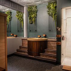 a bathroom with green plants on the wall and wooden steps leading up to the bathtub