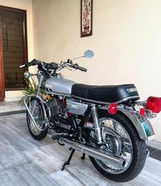 a motorcycle is parked in front of a wall with a potted plant on it