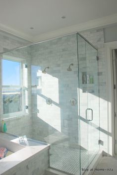 a bathroom with a large window and a walk in shower