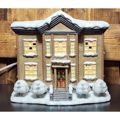 a small toy house with snow on the roof and steps leading up to it's front door