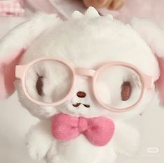 a white stuffed animal with pink glasses on it's face