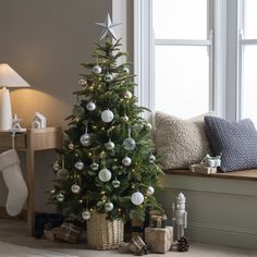 a decorated christmas tree in front of a window