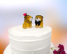 two figurines on top of a white cake