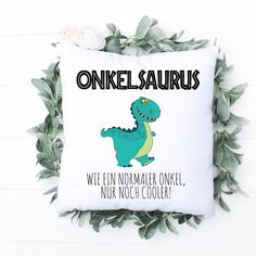 a white pillow with a green dinosaur on it that says,'oinkel saurus we fin nomailer ow