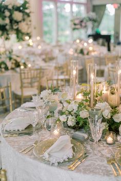 the table is set with white flowers and candles for an elegant wedding reception or special event