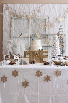 a table topped with a white cake and lots of snowflakes on top of it