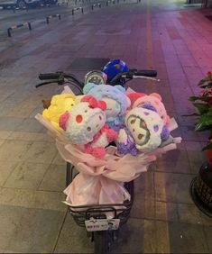 a bunch of stuffed animals sitting on the back of a bike