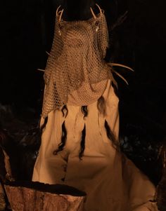 a cloth covered mannequin in the dark