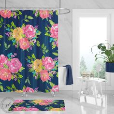 a blue shower curtain with pink flowers on it in front of a white table and potted plant