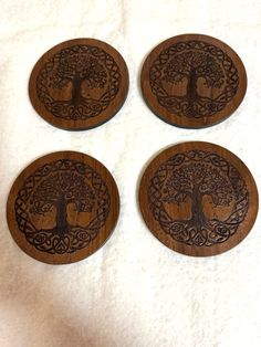 four wooden coasters with trees on them