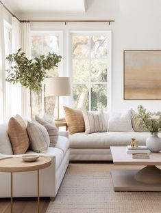 a living room filled with white furniture and lots of windows