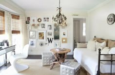 a living room filled with white furniture and pictures on the wall above it's headboard