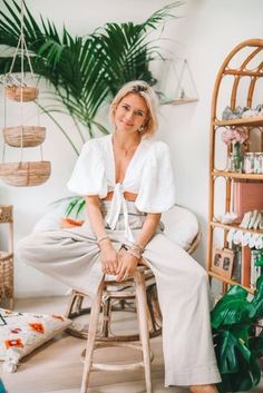 a woman sitting on top of a wooden stool