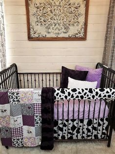 a baby crib with purple and black bedding