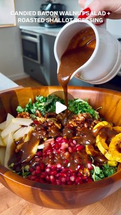 someone pouring sauce into a bowl filled with food