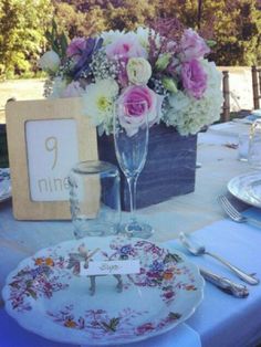 the table is set with flowers and plates