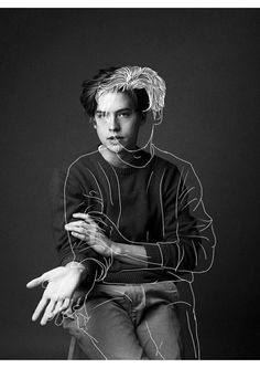 a black and white photo of a man sitting on a chair with headphones in his ears