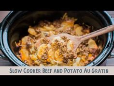 a crock pot filled with pasta and meat is being stirred with a wooden spoon