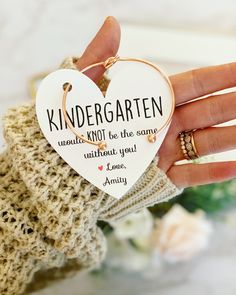 a person holding a heart shaped keychain that says, kindergarten would not be the same without you love