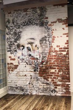 a brick wall with an image of a man's face painted on it