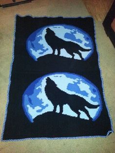 a crocheted rug with two wolfs in the moon and stars on it