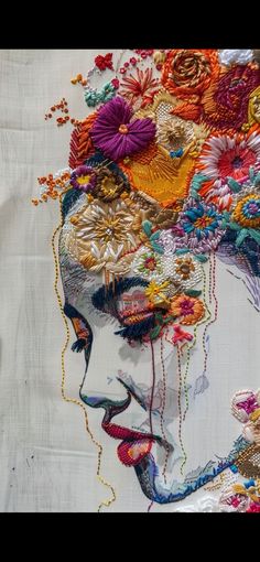 a woman's face is made up of many different colored threads