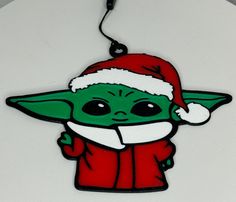 a christmas ornament with a baby yoda wearing a santa hat