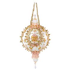 a white and gold beaded ornament hanging from a chain on a white background