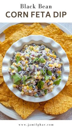 black bean corn feta dip in a white bowl surrounded by tortilla chips