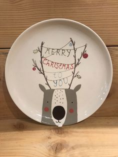 a white plate with a reindeer face and merry christmas to you written on the front