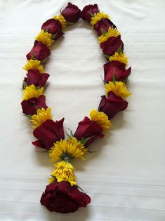 flowers arranged in the shape of a heart on a white sheet with red and yellow petals